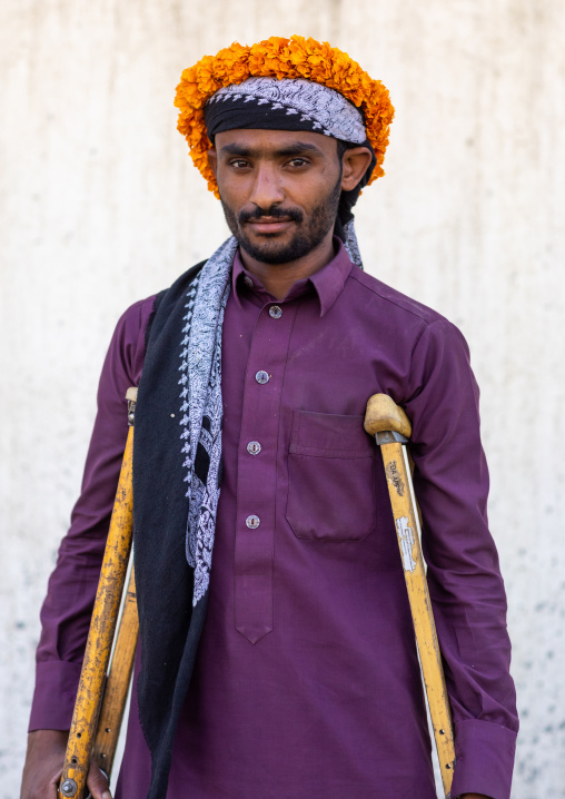 Portrait of a yemeni refugee with crutches wearing a floral crown on the head, Jizan Province, Addayer, Saudi Arabia
