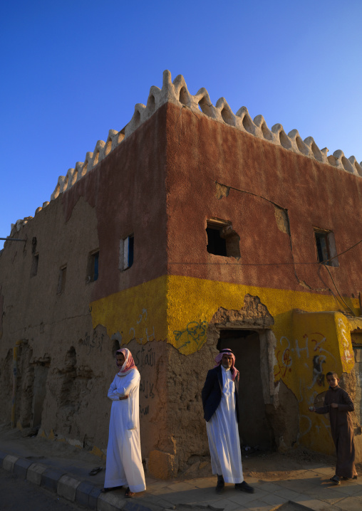 Saudi men in front of an old house, Najran Province, Najran, Saudi Arabia