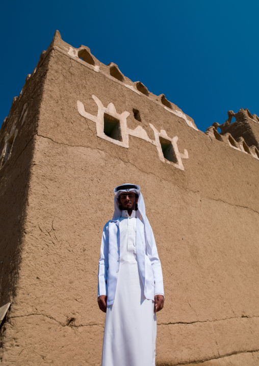 Saudi man in front of a traditional mud-bricks house, Najran Province, Najran, Saudi Arabia