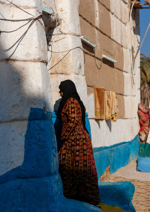 Saudi woman entering a traditional mud-bricks house, Najran Province, Najran, Saudi Arabia