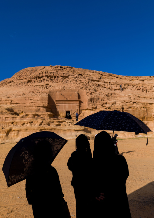 Tourists in front of a nabataean tomb in madain saleh archaeologic site, Al Madinah Province, Al-Ula, Saudi Arabia
