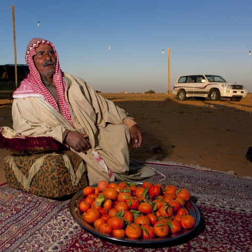 Portrait of a saudi man in the desert with mandarins, Al-Jawf Province, Sakaka, Saudi Arabia