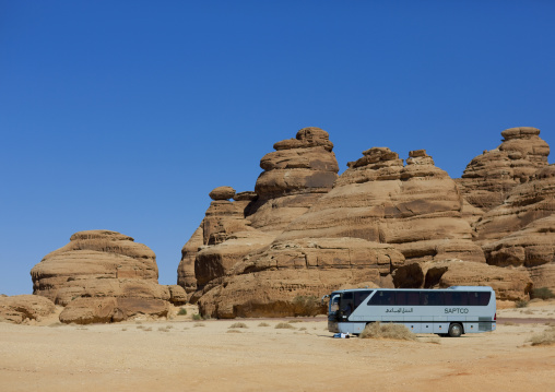 Tourists bus in front of a Nabataean tomb in al-Hijr archaeological site in Madain Saleh, Al Madinah Province, Alula, Saudi Arabia