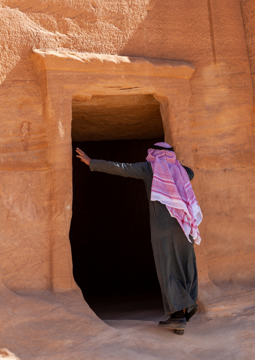 Saudi tourist visiting a nabataean tomb in madain saleh archaeologic site, Al Madinah Province, Al-Ula, Saudi Arabia