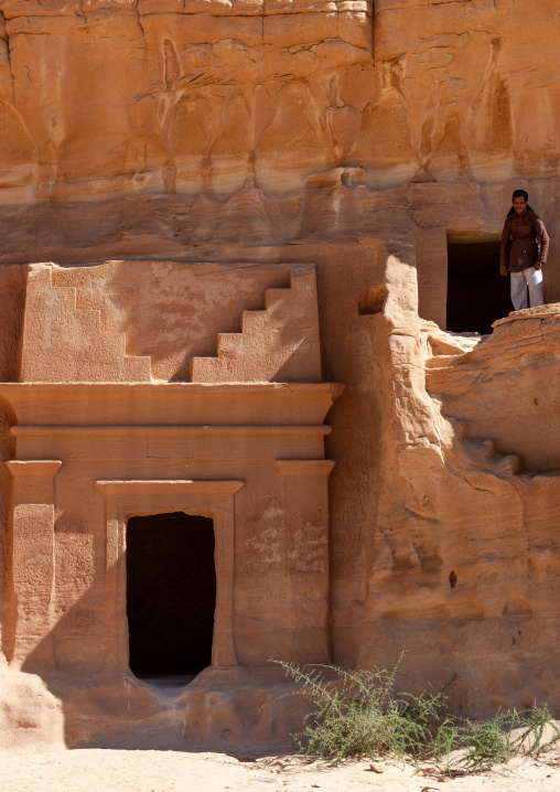 Saudi tourist climbing on a nabataean tomb in madain saleh archaeologic site, Al Madinah Province, Al-Ula, Saudi Arabia