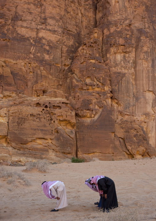 Saudi men praying in the desert, Al Madinah Province, Alula, Saudi Arabia