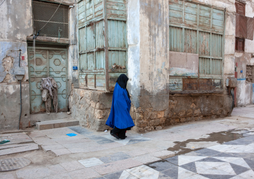 Saudi woman in abaya walking in a street in the old quarter, Hijaz Tihamah region, Jeddah, Saudi Arabia