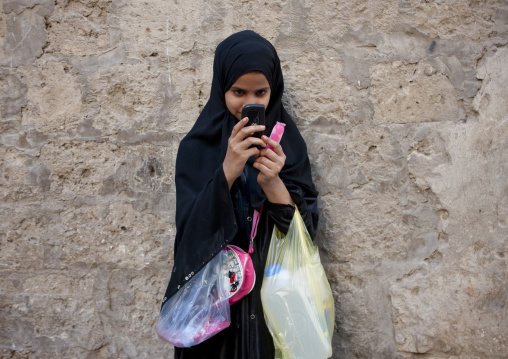 Saudi girl taking picture with mobile phone, Mecca province, Jeddah, Saudi Arabia