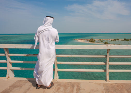 Rear view of a saudi man looking at the red sea from a bridge, Jizan Region, Farasan island, Saudi Arabia
