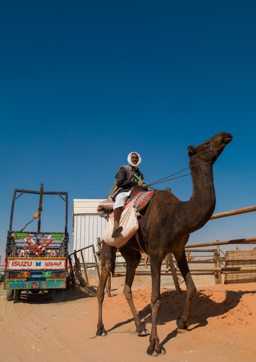 Rashaida sudanese man riding a camel in the market, Riyadh Province, Riyadh, Saudi Arabia