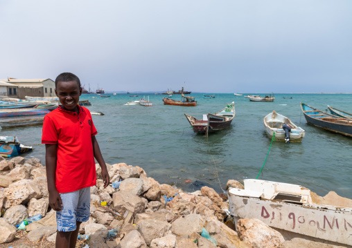 Somali boy in front of stationing boats in the port, Sahil region, Berbera, Somaliland