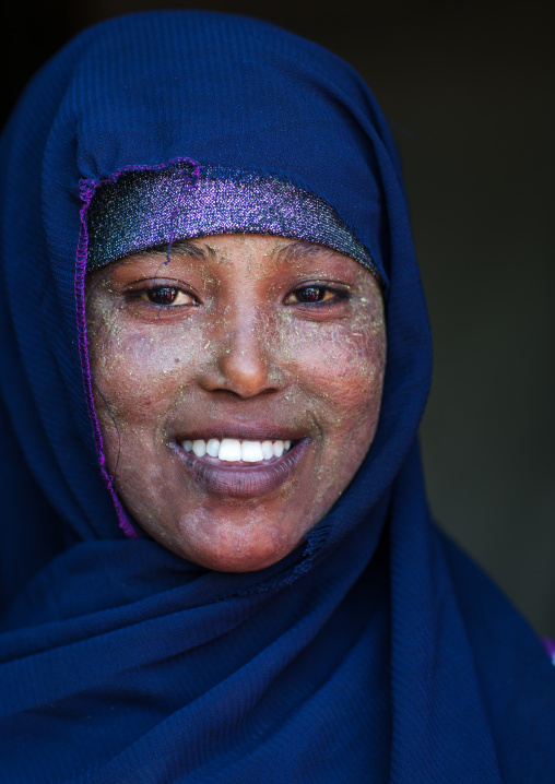 Portrait of a smiling somali woman with qasil on her face and wearing a blue hijab, Woqooyi Galbeed region, Hargeisa, Somaliland