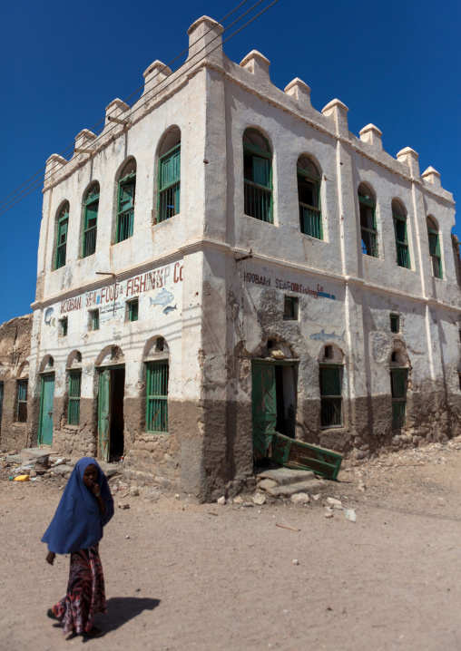Somali woman passing in front of  former ottoman empire house, North-Western province, Berbera, Somaliland