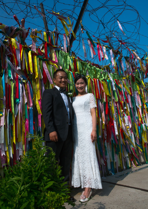 North korean defector joseph park with his south korean fiancee juyeon in front of messages of peace written on ribbons left on dmz, Sudogwon, Paju, South korea
