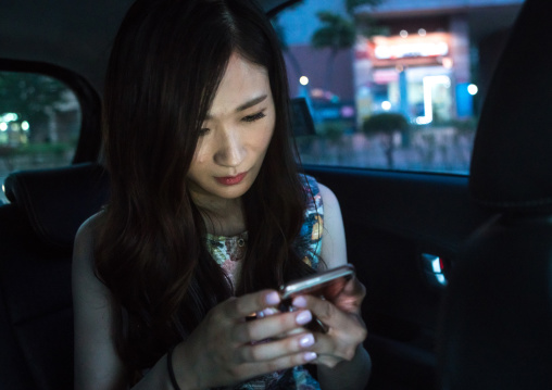 South korean woman called juyeon reading text messages on her mobile phone, National capital area, Seoul, South korea