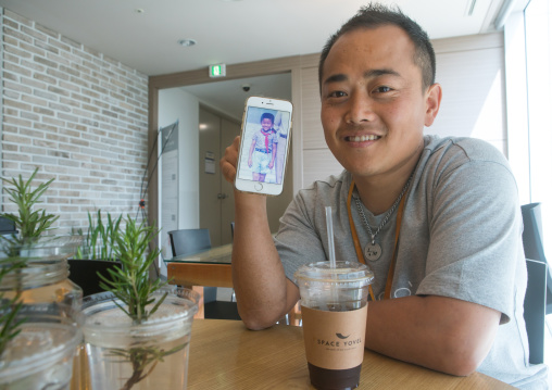 North korean defector joseph park in yovel cafe showing a picture of himself taken in north korea, National capital area, Seoul, South korea