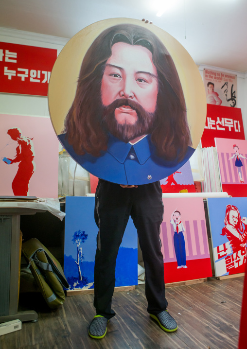 Sun mu artist hiding behind a painting of kim jong il looking like jesus, National capital area, Seoul, South korea