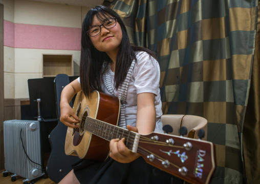 North korean teen defector in yeo-mung alternative school playing guitar, National capital area, Seoul, South korea