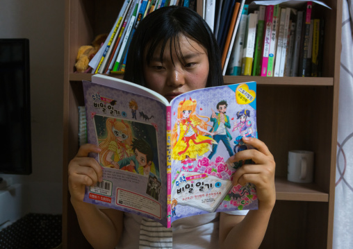 North korean teen defector reading a korean manga book, National capital area, Seoul, South korea