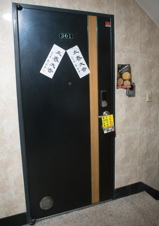 Door of an apartement with advertisements for pizzaq sticked on it, National capital area, Seoul, South korea