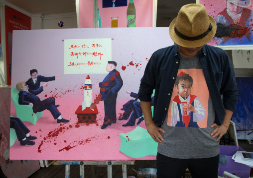 North Korean artist Sun Mu in front of a painting with Donald Trump and Kim Jong Un, National Capital Area, Seoul, South Korea