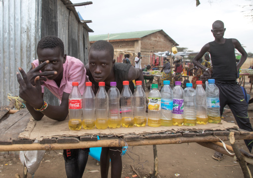 Toposa tribe men selling oil in plastic bottles in a market, Namorunyang State, Kapoeta, South Sudan