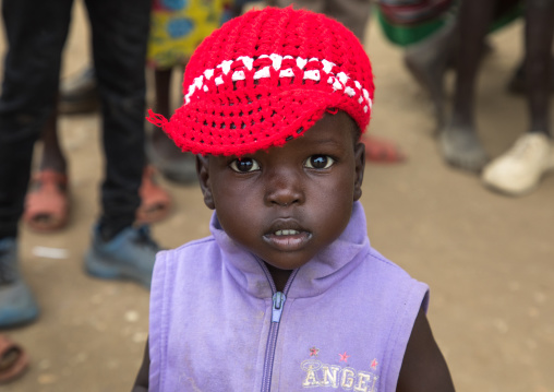 Portrait of a Toposa girl with a red Knit Hat, Namorunyang State, Kapoeta, South Sudan
