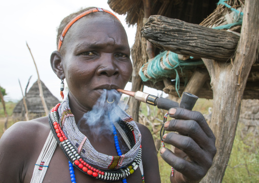 Toposa tribe woman smoking pipe in a village, Namorunyang State, Kapoeta, South Sudan