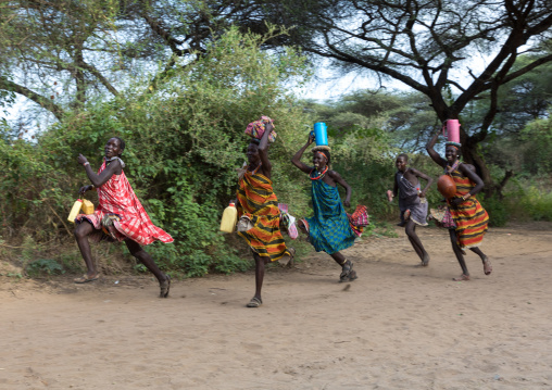 Toposa tribe women running with stuff on their heads, Namorunyang State, Kapoeta, South Sudan