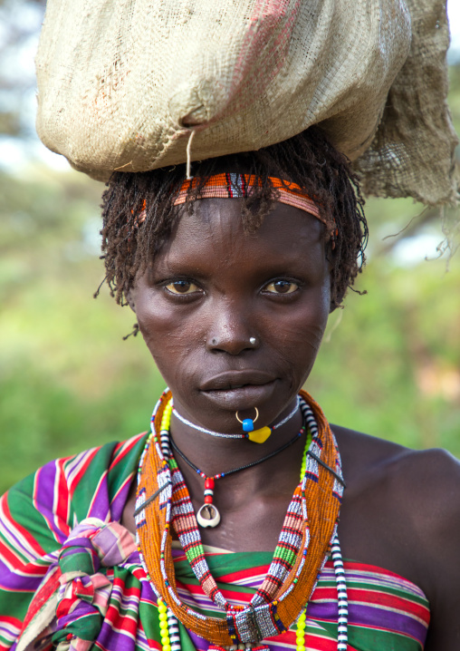 Portrait of a Toposa tribe woman carrying stuff on her head, Namorunyang State, Kapoeta, South Sudan