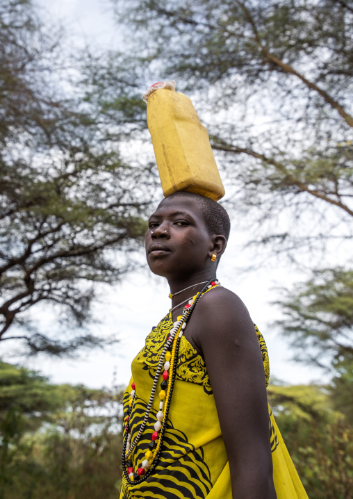Toposa tribe woman carrying a jerrycan on her head, Namorunyang State, Kapoeta, South Sudan