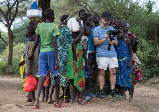 Western tourist filming surrended by Toposa tribe people, Namorunyang State, Kapoeta, South Sudan