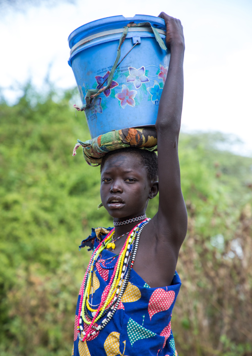 Toposa tribe girl carrying a bucket on her head, Namorunyang State, Kapoeta, South Sudan