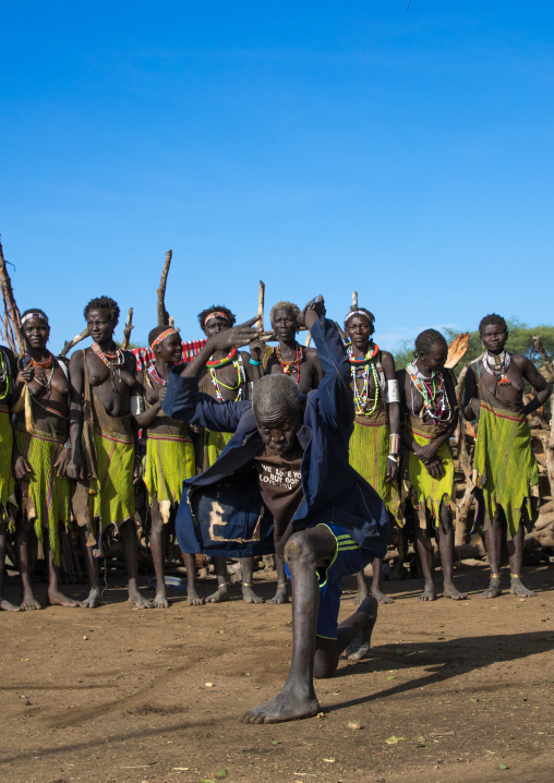 Toposa tribe man dancing in front of women during a ceremony, Namorunyang State, Kapoeta, South Sudan