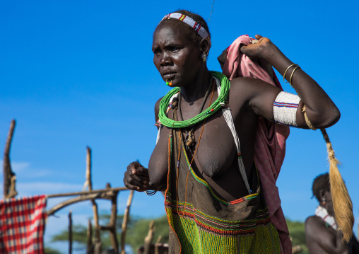 Toposa tribe woman in traditional clothing dancing during a ceremony, Namorunyang State, Kapoeta, South Sudan