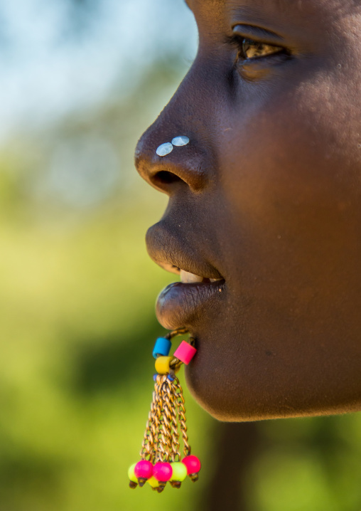 Close up of the face of a Larim tribe woman with a chin labret, Boya Mountains, Imatong, South Sudan