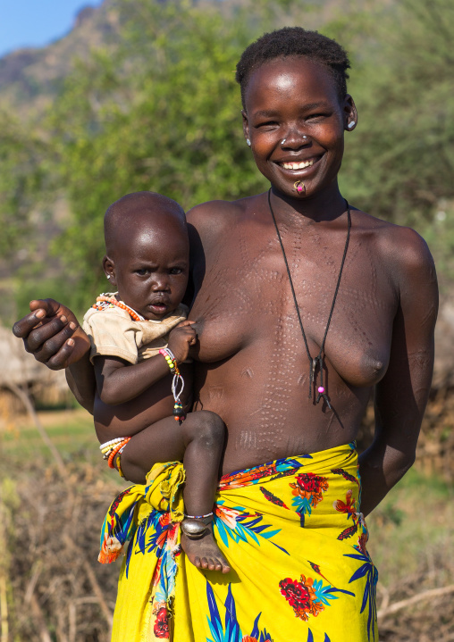 Smiling Larim tribe woman carrying her baby, Boya Mountains, Imatong, South Sudan