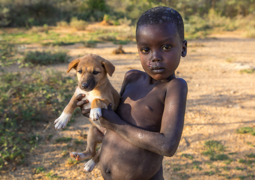 Larim tribe boy holding a puppy, Boya Mountains, Imatong, South Sudan