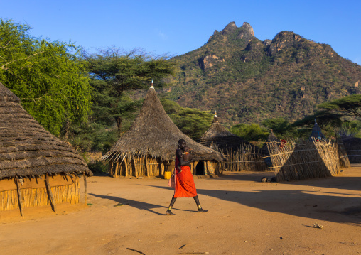 Woman passing in a Larim tribe traditional village, Boya Mountains, Imatong, South Sudan