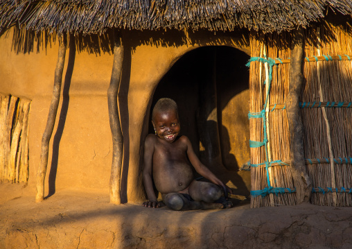 Larim tribe boy sit at the entrance of his hut, Boya Mountains, Imatong, South Sudan