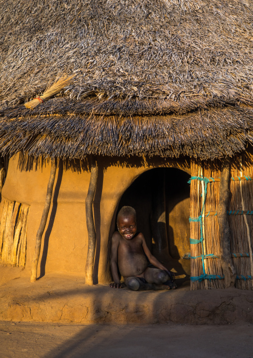Larim tribe boy sit at the entrance of his hut, Boya Mountains, Imatong, South Sudan