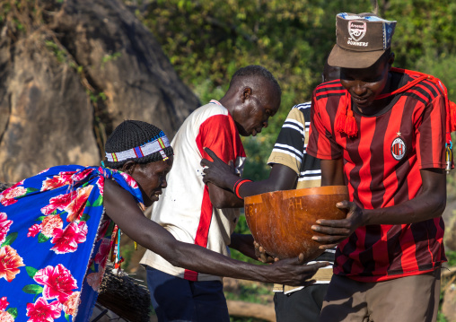 Larim tribe people carrying alcohol in a calabash during a wedding ceremony, Boya Mountains, Imatong, South Sudan