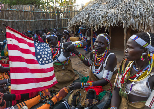 Larim tribe women with an american flag during a wedding celebration, Boya Mountains, Imatong, South Sudan