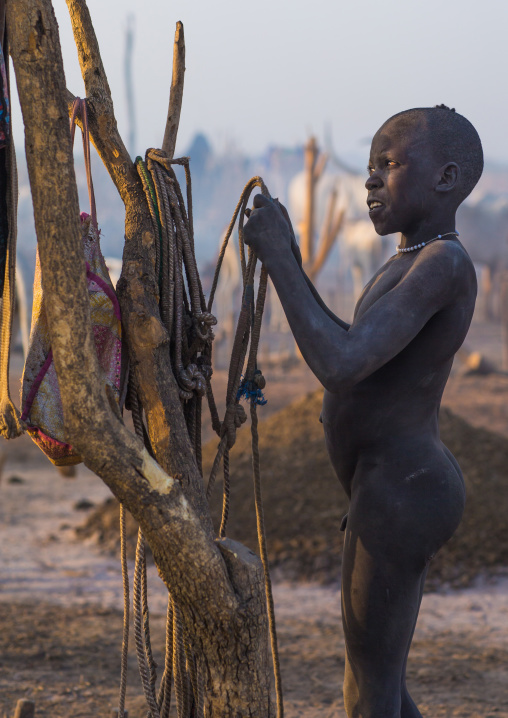 A Mundari tribe boy prepares the ropes to tie the cows in a cattle camp, Central Equatoria, Terekeka, South Sudan