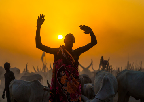 A Mundari tribe man mimics the position of horns of his favourite cow in the sunset, Central Equatoria, Terekeka, South Sudan