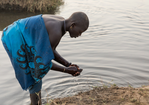 Mundari tribe women washing her hands in river Nile, Central Equatoria, Terekeka, South Sudan