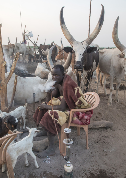 Mundari tribe man smoking shisha in a cattle camp, Central Equatoria, Terekeka, South Sudan