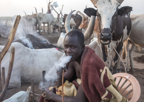 Mundari tribe man smoking shisha in a cattle camp, Central Equatoria, Terekeka, South Sudan