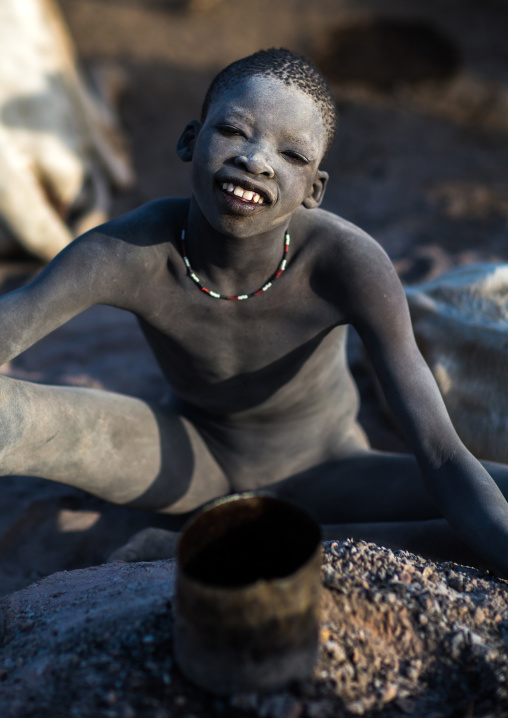 Smiling Mundari tribe boy covered in ash to repel flies and mosquitoes in a cattle camp, Central Equatoria, Terekeka, South Sudan