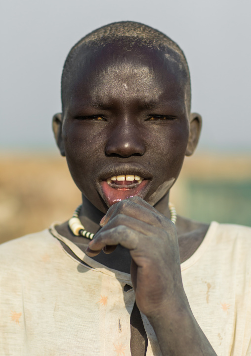 Portrait of a Mundari tribe boy shiwing his lower teeth traditionally removed, Central Equatoria, Terekeka, South Sudan